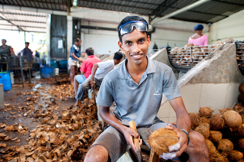 Smiling worker with coconut.